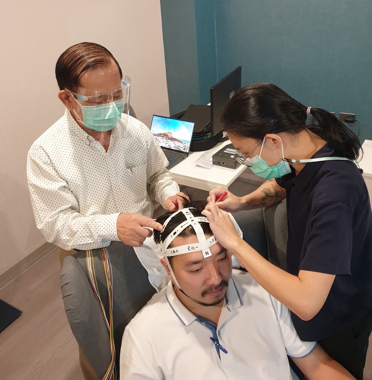 อาจารย์อุบล ปาระมี กำลังติดอุปกรณ์วัดสัญญาณสมองสำหรับตรวจการนอน ศูนย์ชีวานิทราเวช